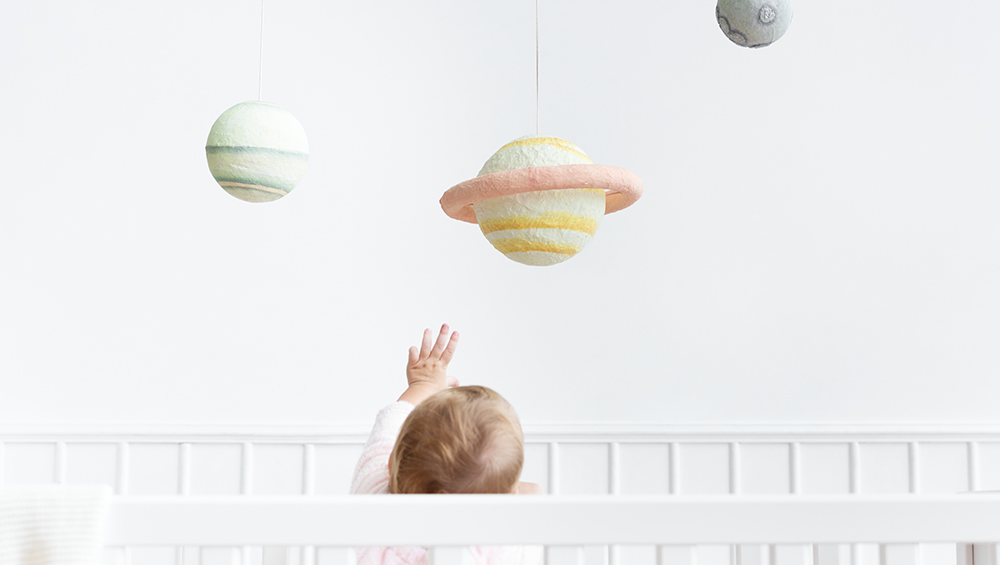 Baby trying to reach plushie planet Saturn